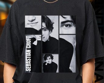 May include: Black t-shirt featuring a collage of black and white images of a person. The name "SEBASTIAN CROFT" is printed vertically on the left side of the shirt. The collage includes close-ups of the person's face and full body shots.