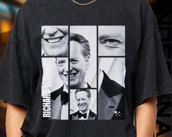 May include: Black t-shirt featuring a collage of black and white images of Richard E. Grant. The design includes close-ups of his face and a full portrait, with the name "RICHARD E. GRANT" printed vertically on the left side.