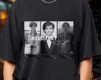 May include: Black t-shirt featuring a black and white image of a person in three panels. The image has the name "Sebastian Croft" in white text. The shirt is a crew neck style.