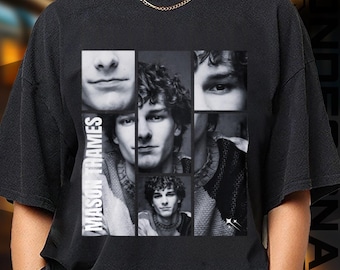 May include: Black t-shirt featuring a collage of black and white images of a person's face. The name "MASON THAMES" is printed vertically in white on the left side of the shirt. The collage includes close-ups of the eyes, mouth, and full face.