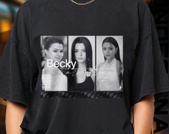 May include: Black t-shirt featuring a grayscale image of three women. The image is divided into three vertical panels with the name "Becky Armstrong" printed in white. The shirt has a crew neck and short sleeves.