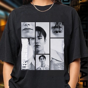 May include: Black t-shirt featuring a collage of black and white photographs of a man's face. The text "LEE JAEHOOK" is printed vertically on the left side of the shirt.