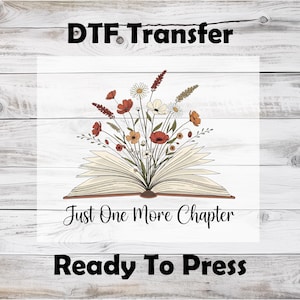 May include: DTF Transfer design featuring an open book with a bouquet of flowers. The flowers are in shades of red, orange, and white. The text "Just One More Chapter" is below the book, and "Ready To Press" is at the bottom.