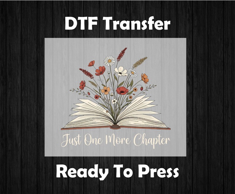 May include: DTF transfer design featuring an open book with a bouquet of flowers. The flowers include red poppies, white daisies, and orange blooms. The text "Just One More Chapter" is below the book, with "Ready To Press" at the bottom.