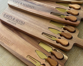 May include: Set of four wooden cheese boards with engraved names and dates. Each board includes a set of four gold-toned cheese knives with wooden handles.