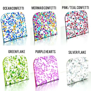 May include: Six samples of confetti in various colors and shapes. The samples are labeled "Ocean Confetti", "Mermaid Confetti", "Pink/Teal Confetti", "Greenflake", "Purple Hearts", and "Silverflake". Each sample is in a clear, rectangular container.