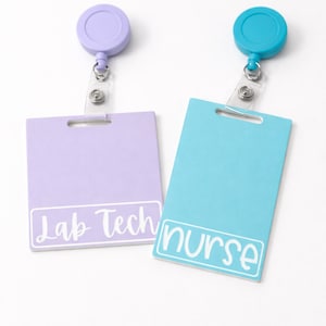May include: Two retractable badge holders. One is lavender with "Lab Tech" in white script, the other is turquoise with "nurse" in white script. Both have a clear plastic strap and a matching colored disc.