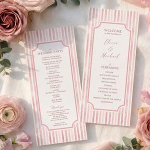May include: Two pink and white striped wedding programs with text, surrounded by pink roses and greenery. The programs feature the names Cleeve & Michael and details of the ceremony and wedding party.