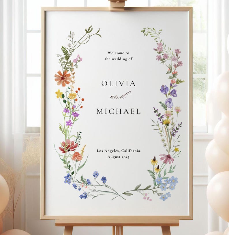 May include: A wedding sign with a floral wreath design. The sign says "Welcome to the wedding of Olivia and Michael, Los Angeles, California, August 2025".