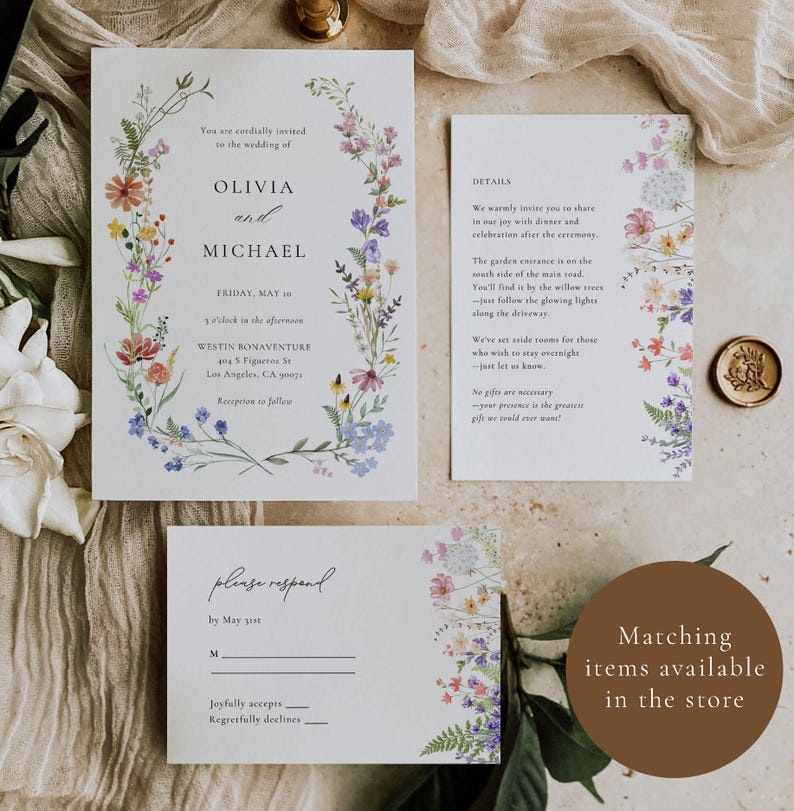 May include: Wedding invitation suite with floral designs. The invitation features a wreath of colorful flowers with the names Olivia and Michael. The details card includes information about the ceremony and reception. The RSVP card has a floral border and a place to indicate acceptance or decline.