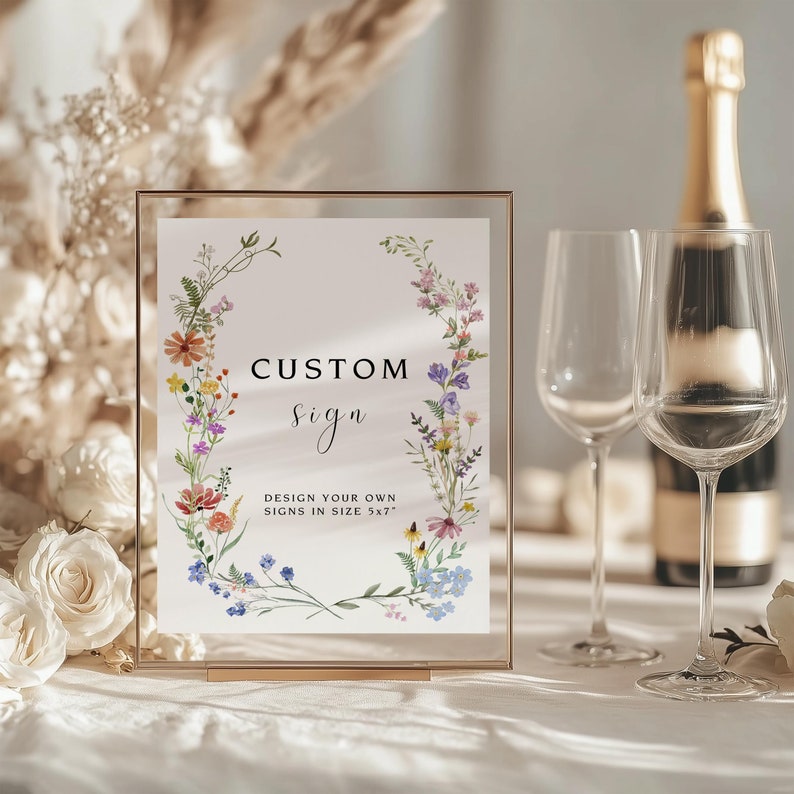 K&ouml;nnte beinhalten: Ein goldfarbener Rahmen mit einem Aquarell-Blumenkranz und dem Text "CUSTOM sign DESIGN YOUR OWN SIGNS IN SIZE 5x7"