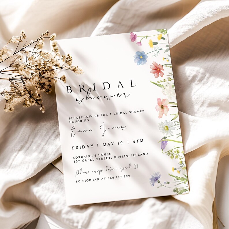May include: A white bridal shower invitation with a floral border. The invitation reads "BRIDAL shower" in black script font. The text "PLEASE JOIN US FOR A BRIDAL SHOWER HONORING Emma Jones FRIDAY MAY 19 | 4 PM LORRAINE'S HOUSE 157 CAPEL STREET, DUBLIN, IRELAND Please RSVP before April 21 TO SIOBHAN AT 666.777.999" is printed in black.