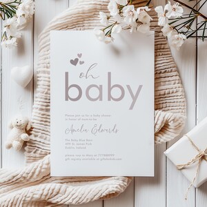 May include: A white baby shower invitation with pink hearts and the text "oh baby" in a pink gradient. The invitation includes the name "Amelia Edwards" and details for the shower, including the location, date, and contact information.