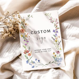 K&ouml;nnte beinhalten: Ein wei&szlig;es Schild mit einem floralen Rand und dem Text "CUSTOM sign DESIGN YOUR OWN SIGNS IN SIZE 5x7"
