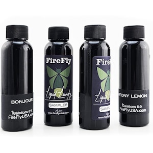 May include: Four small black bottles with labels. The bottles are labeled with the text "FireFly Liquid Laundry" and "Sampler" and the text "Galations 6:9 FireFlyUSA.com". The bottles are labeled with different scents: "Bonjour", "Peony Lemon", and "Sampler".