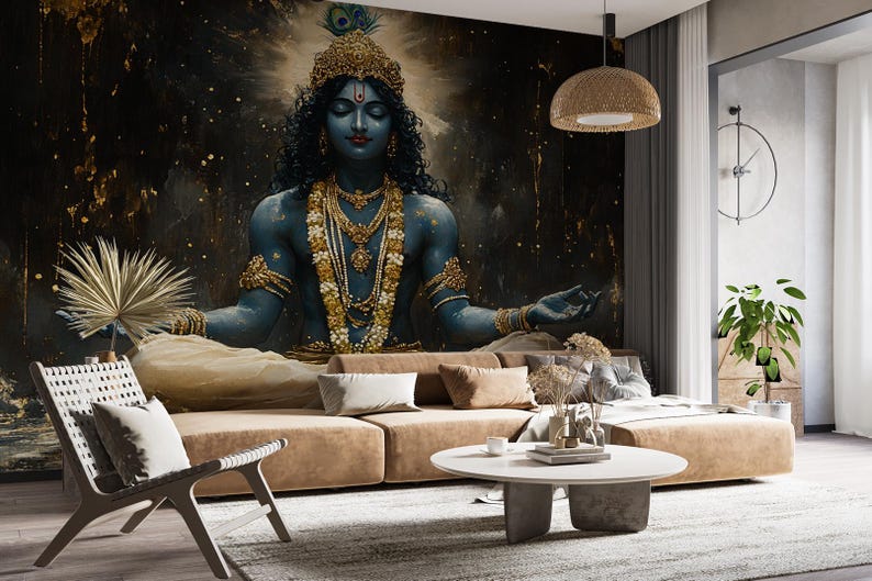May include: A blue and gold deity with closed eyes sits in a meditative pose against a dark blue and gold background. The deity is adorned with jewelry and a peacock feather headdress.