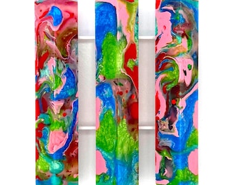 May include: Three vertical rectangular resin blanks labeled 2, 3, and 6, featuring a vibrant marbled pattern of pink, bright blue, lime green, and red swirls. The text Reg appears in the bottom left corner of the image.