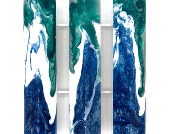 May include: Three rectangular resin turning blanks labeled 1, 3, and 4, featuring a marbled swirl pattern in shades of deep blue, teal, and white. Each vertical block displays a unique, fluid color transition with glossy surfaces.