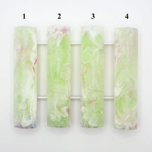 May include: Four rectangular resin blanks arranged vertically, labelled 1 through 4. Each blank features a marbled pattern of translucent light green, opaque white, and small flecks of pink, blue, and gold glitter embedded within the material.