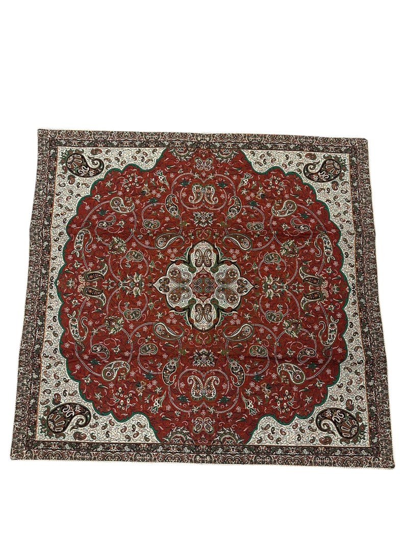 May include: A rectangular, ornate rug with a central medallion design. The rug features a deep red background with intricate paisley and floral patterns in white, green, and brown. The border is a darker brown with a repeating pattern.