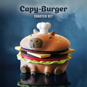 Pode incluir: Um conjunto de bases para copos extravagantes em forma de hambúrguer de capivara. A parte superior da bolacha castanha apresenta um chapéu de chef branco, com camadas de queijo, tomate e alface. O texto "Capy-Burger COASTER SET" é exibido acima.