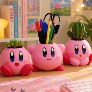 May include: Three pink, round, character-shaped containers with blue and black eyes. The left one holds a green succulent, the center one holds various colored pens and pencils, and the right one holds a green cactus. Each has small red feet.
