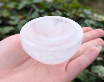 May include: A set of three white selenite bowls, nested together. The bowls are smooth and have a slightly translucent appearance.
