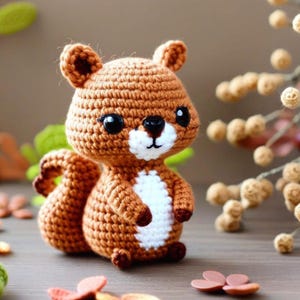 Peut inclure: Un jouet en crochet amigurumi en forme d'écureuil avec une fourrure brune, un ventre blanc et des yeux noirs. Le jouet est assis sur une surface en bois avec des feuilles brunes éparpillées autour.