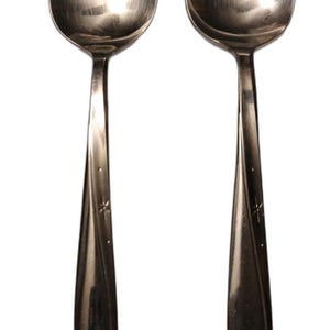 Op de afbeelding: Twee identieke zilverkleurige metalen lepels met een gepolijste afwerking. Elke lepel heeft een slank handvat dat is versierd met een subtiel, gegraveerd sterpatroon bij de hals en aan de onderkant voor een strakke uitstraling.
