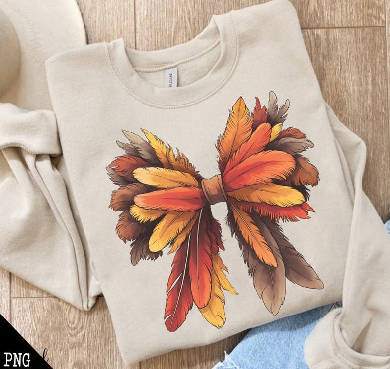May include: A beige sweatshirt with a large, colorful bow made of feathers. The bow is made of red, orange, yellow, and brown feathers. The feathers are arranged in a way that looks like a bow. The sweatshirt is a great way to show your love for fall.