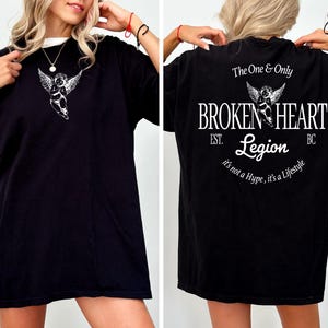 Black t-shirt with "The One & Only BROKEN HEART Legion" graphic on back.