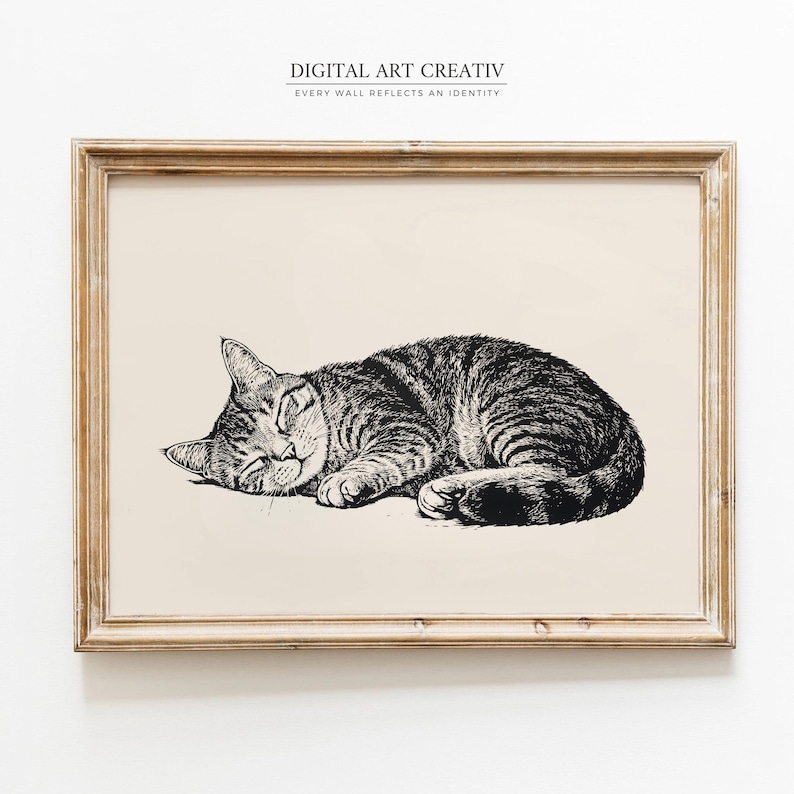 Pode incluir: Uma impress&atilde;o emoldurada com uma ilustra&ccedil;&atilde;o detalhada em preto e branco de um gato tigrado a dormir. O gato est&aacute; enroscado, com os olhos fechados, a descansar sobre um fundo creme. A moldura &eacute; de cor castanho claro, e a impress&atilde;o tem o texto "DIGITAL ART CREATIV" e "EVERY WALL REFLECTS AN IDENTITY".