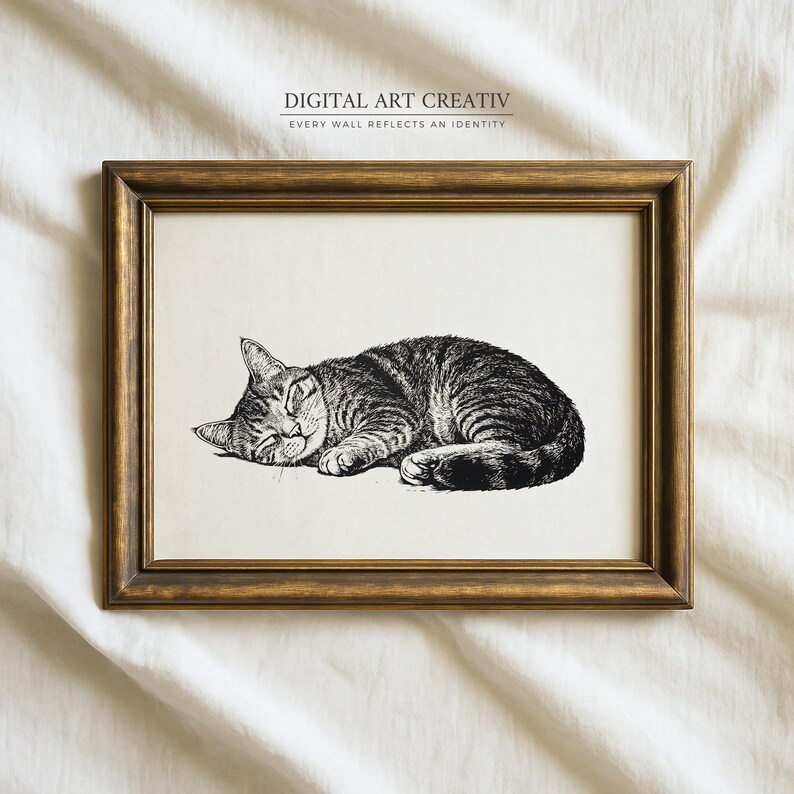 Pode incluir: Uma impress&atilde;o emoldurada com uma ilustra&ccedil;&atilde;o detalhada em preto e branco de um gato malhado dormindo. A obra de arte est&aacute; em um fundo creme e emoldurada em uma moldura de madeira dourada. O texto "DIGITAL ART CREATIV" e "EVERY WALL REFLECTS AN IDENTITY" &eacute; impresso no topo.