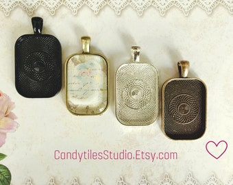 May include: Four different metal pendant trays with a decorative swirl pattern. The trays are rectangular and have a silver, black, gold, and bronze finish.