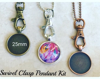 May include: Three swivel clasp pendant kits with 25mm round glass cabochons. The kits include a silver, bronze, and copper chain and clasp. One cabochon has a colorful abstract design, and the other two are blank.