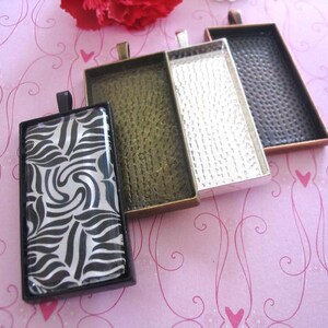 Puede incluir: Cuatro marcos rectangulares de metal con acabado plateado, cobre, negro y dorado. Los marcos est&aacute;n dise&ntilde;ados para contener un inserto de vidrio o pl&aacute;stico para la elaboraci&oacute;n de joyas.