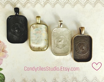 May include: Four different metal pendant trays with a decorative swirl pattern. The trays are rectangular and have a silver, black, gold, and bronze finish.
