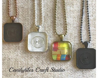 May include: Four square pendant trays with different chain styles. The trays are silver, black, bronze, and copper. The bronze tray has a colorful abstract design inside. The text "Candytiles Craft Studio" is at the bottom of the image.