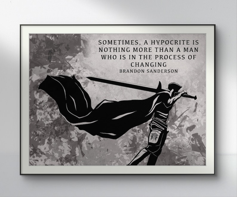 May include: Framed black and white art print. The image shows a silhouette of a figure with a sword and cape, with the quote: "Sometimes, a hypocrite is nothing more than a man who is in the process of changing" by Brandon Sanderson.