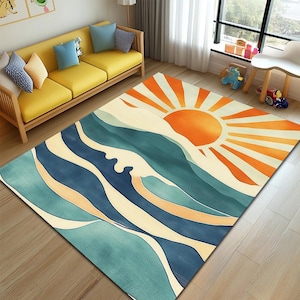 May include: A rectangular area rug featuring a watercolor design of a sunrise over ocean waves. The rug has a blue, orange, and cream color palette. The sun is a bright orange, and the waves are various shades of blue.
