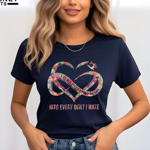 May include: Navy blue t-shirt with a colorful heart-shaped design and the text "I sew a piece of my heart into every quilt I make." The design includes a sewing machine and infinity symbol.