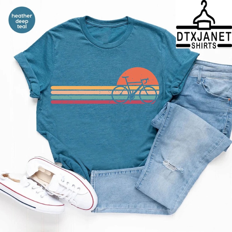 a t - shirt with a bicycle on it and a pair of jeans
