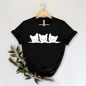 a black shirt with three cats on it