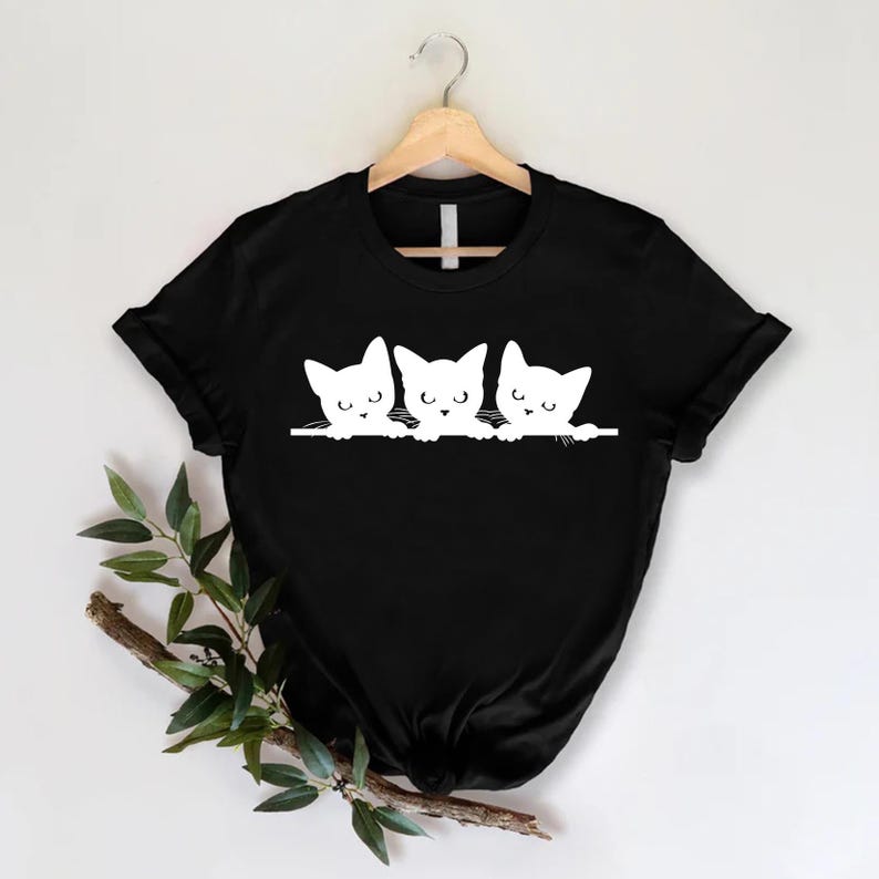 a black shirt with three cats on it