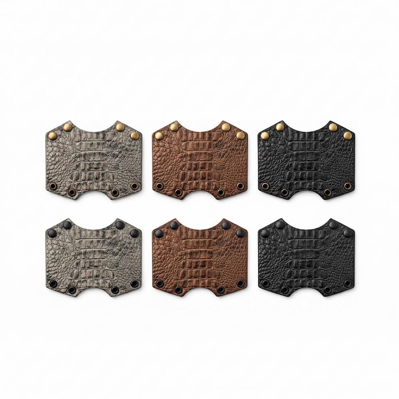 May include: Six rectangular cuffs with a textured crocodile skin pattern, arranged in two rows. The top row features brass-colored metal studs, while the bottom row has black metal studs. Each piece has a curved cutout on the top and bottom edges.