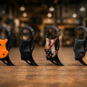 May include: Four folding karambit knives with integrated carabiner clips. The first has an orange handle, the second is matte black, the third features a distressed American flag pattern, and the fourth has a black handle with a tan blade.