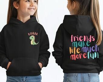 May include: Two children wearing black hoodies with a dinosaur graphic and the text "Roar" on one hoodie and the text "Friends make life much more fun" on the other hoodie. Both children are wearing blue jeans.