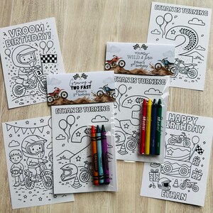May include: A selection of birthday-themed colouring pages and crayon sets. The pages feature motocross bikes, helmets, and the text "Vroom Birthday!", "Ethan is Turning", and "Happy Birthday". The crayon sets include red, orange, yellow, green, blue, and purple crayons.
