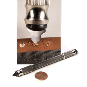 May include: A silver and black hand-held leather punch tool with a pointed tip. The tool is shown punching holes in a piece of brown leather. A ruler is visible in the background. A penny is shown for scale.