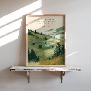 May include: Framed art print featuring a landscape scene with rolling green hills, winding paths, and evergreen trees. The artwork includes the quote: "Of all the paths you take in life, make sure a few of them are dirt."